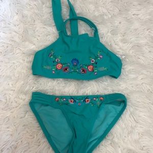 Two piece turquoise bikini with colorful flowers on top and bottom pieces